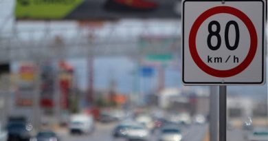 Una señaletica de límite de velocidad y al fondo se ve una carretera